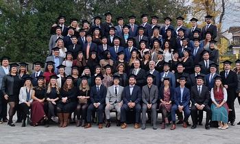 Gruppenfoto von Absolventinnen und Absolventen der FH Burgenland in festlicher Kleidung und Sponsionshüten bei der Sponsion im Schloss Esterházy – ein Moment des Stolzes und gemeinsamer Freude.