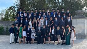 Gruppenfoto von 51 Absolventinnen und Absolventen der FH Burgenland in feierlicher Kleidung vor dem Schloss Esterházy nach der Sponsionsfeier.