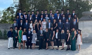 Gruppenfoto von 51 Absolventinnen und Absolventen der FH Burgenland in feierlicher Kleidung vor dem Schloss Esterházy nach der Sponsionsfeier.