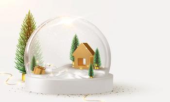 Weihnachtliche Schneekugel mit kleiner goldener Hütte, Tannenbäumen und Schneelandschaft auf hellem Hintergrund. Daneben liegt eine Lichterkette. Die Grafik vermittelt festliche Stimmung zur Weihnachtszeit.