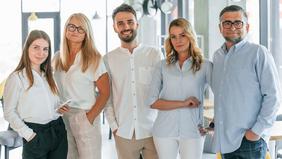 Neue Masterprogramme für Berufserfahrene ohne Matura oder Vorstudium Fünf Erwachsene unterschiedlichen Alters stehen nebeneinander in heller, moderner Büroumgebung. Sie blicken selbstbewusst in die Kamera – sinnbildlich für die Zielgruppe der neuen Masterprogramme an der Hochschule Burgenland, die sich nun auch ohne Matura oder akademischen Abschluss weiterbilden kann.