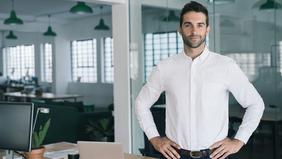 MBA Agiles Management Selbstbewusster junger Mann in modernem Büro – steht sinnbildlich für innovative Führungskompetenz im Rahmen des MBA Agiles Management der FH Burgenland.