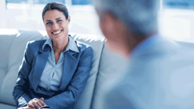 Business-Frau im Gespräch mit einer anderen Person in moderner Büroumgebung – symbolisiert rechtliche und wirtschaftliche Beratung im Rahmen des MBA Wirtschaftsrecht der FH Burgenland.