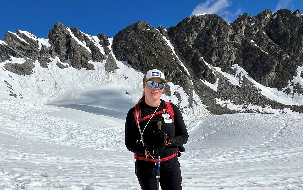 Maxi Müller bei einer Schneewanderung in alpiner Umgebung. Mit Trekkingstöcken und sportlicher Kleidung steht sie vor einer beeindruckenden Bergkulisse – ein Moment der Stärke und Entschlossenheit.