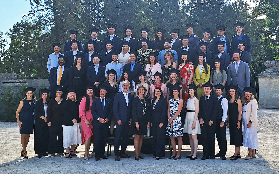 Absolvent*innen der FH Burgenland feiern gemeinsam bei der Sponsion 2024 vor dem Schloss Esterházy – Gruppenbild mit Stolz und Freude.
